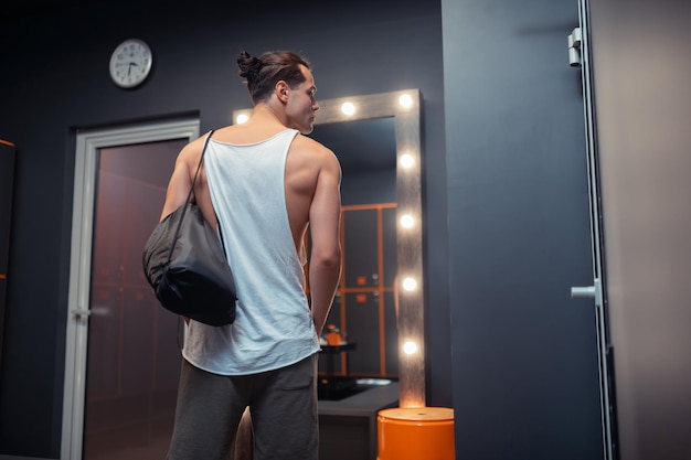 Handsome athletic man standing in the changing room