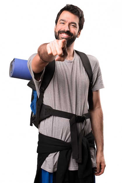 Handsome backpacker pointing to the front 