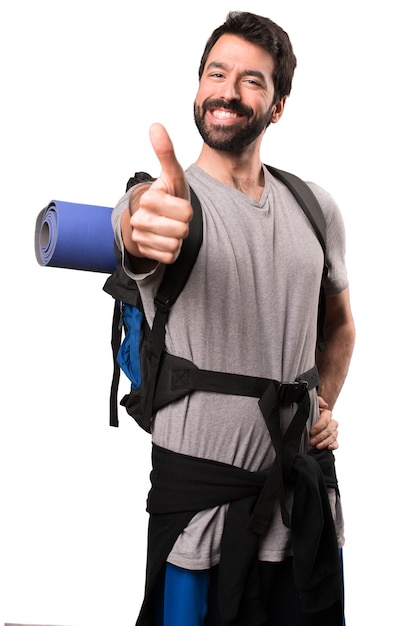 Handsome backpacker with thumb up on white background