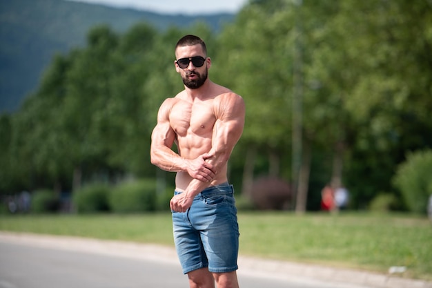 Handsome Beard Man Standing Strong and Posing at Outdoors - Background Nature of Leaves