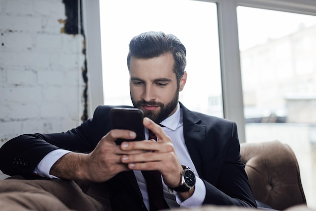 Handsome bearded businessman using smartphone