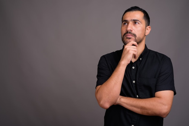 Handsome bearded man against gray wall