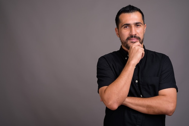 Handsome bearded man against gray wall