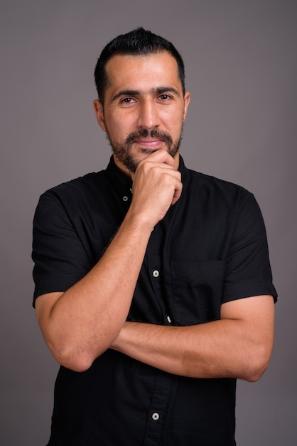 Handsome bearded man against gray wall