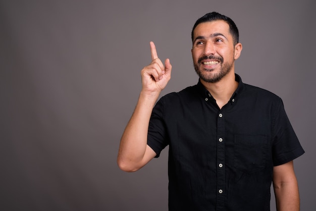 Handsome bearded man against gray wall