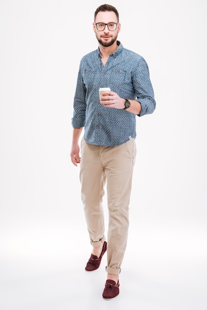 Handsome bearded man standing with cup of coffee