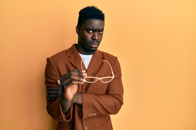 Handsome black man wearing elegant clothes and glasses clueless and confused expression doubt concept