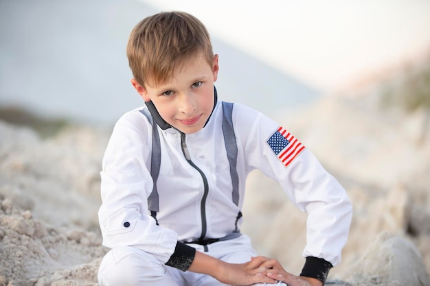 A handsome boy dressed as an American astronaut smiles and looks into the camera