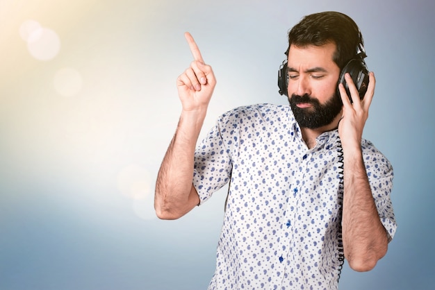 Handsome brunette man with beard listening music