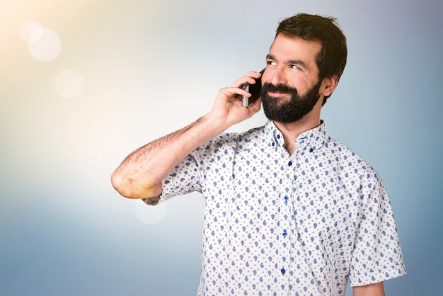 Handsome brunette man with beard talking to mobile