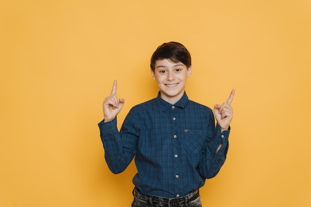 Handsome brunette schoolboy dressed in casual shirt and jeans