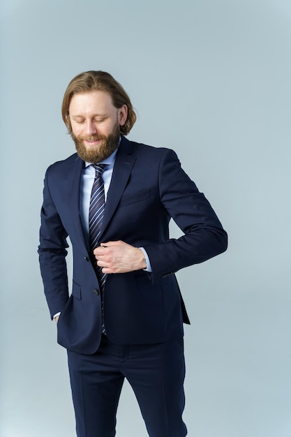 A handsome brutal bearded and longhaired man a stylish businessman on a white background