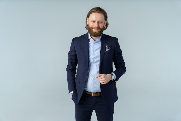 a handsome brutal bearded and longhaired man a stylish businessman on a white background