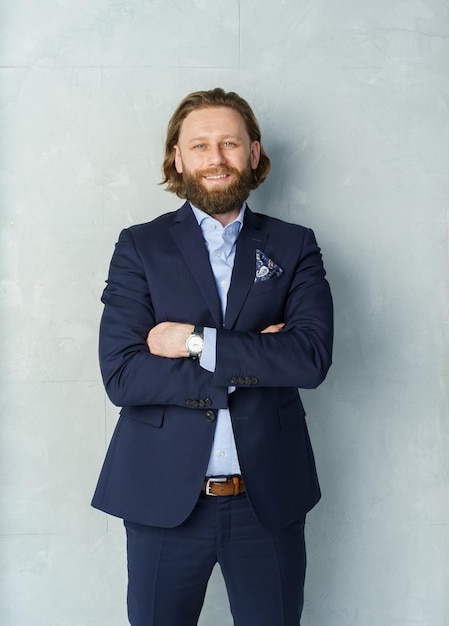 A handsome brutal bearded and longhaired man a stylish businessman on a white background