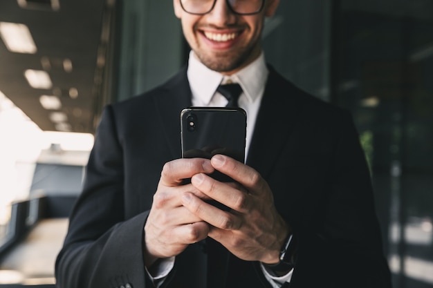 Handsome business man near business center using mobile phone.