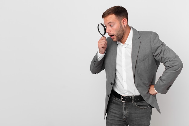 Handsome businessman finfing with a magnifying glass