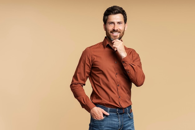 handsome businessman manager looking at camera and thinking isolated on beige background