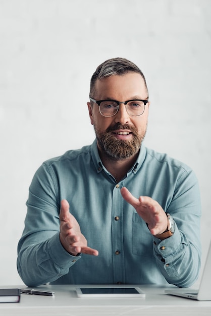 handsome businessman in shirt showing gesture and looking at camera