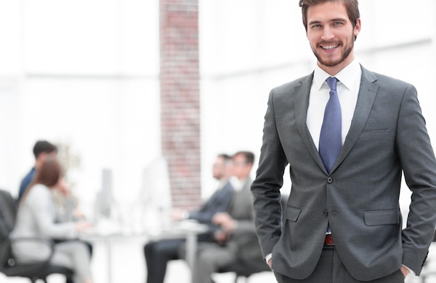 Handsome businessman smiling with his colleagues behind