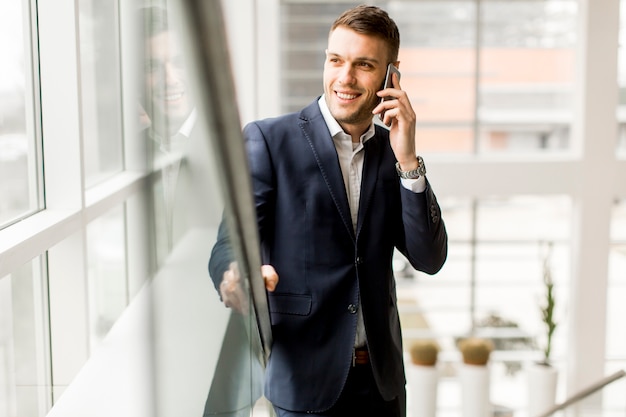 Handsome businessman talking on mobile phone while standing on the stairs