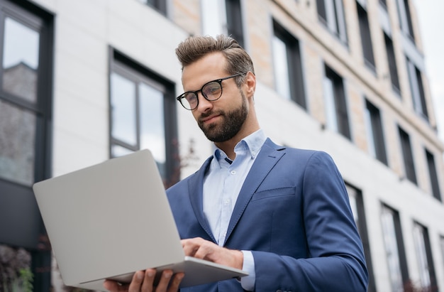 Handsome businessman using laptop computer working online searching something Successful business