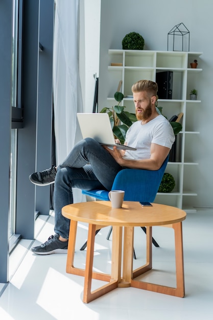 Handsome businessman working with laptop in office.