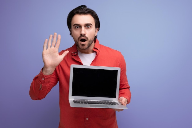 Handsome caucasian brunet young man showing laptop screen to insert promotional offer