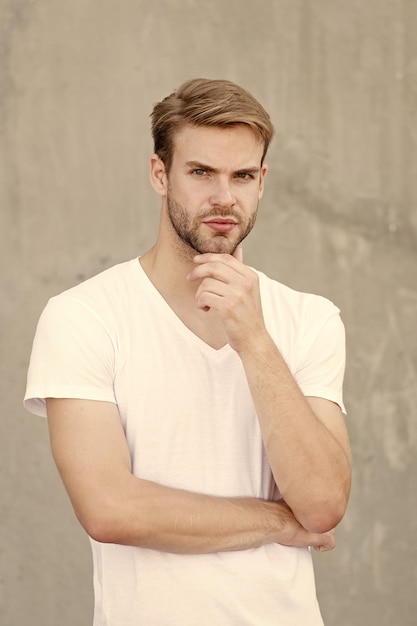 Handsome caucasian man gray background Ideal traits that make man physically attractive Bearded guy casual style close up Male beauty standards Handsome man unshaven face stylish hairstyle