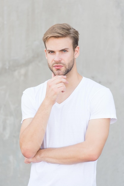 Handsome caucasian man gray background Ideal traits that make man physically attractive Bearded guy casual style close up Male beauty standards Handsome man unshaven face stylish hairstyle