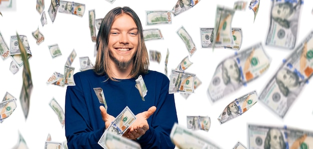 Handsome caucasian man with long hair wearing casual winter sweater smiling with hands palms together receiving or giving gesture hold and protection