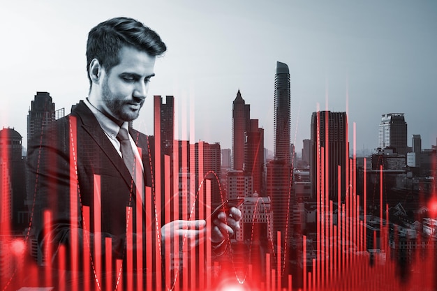 Handsome Caucasian trader checking quotes to forecast the capital market behavior Concept of trading strategy Forex chart Bangkok Double exposure