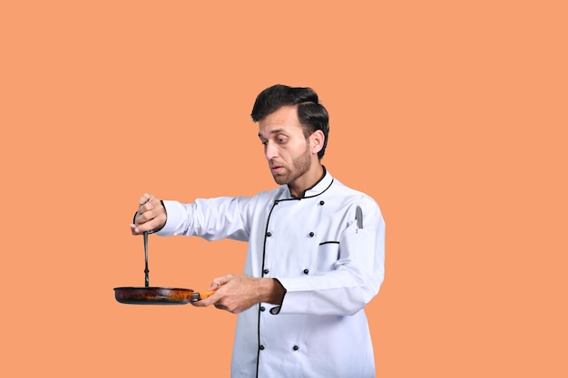 handsome chef cook holding fry pan indian pakistani model