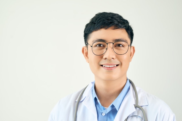 A handsome doctor with stethoscope standing confidently on white wall