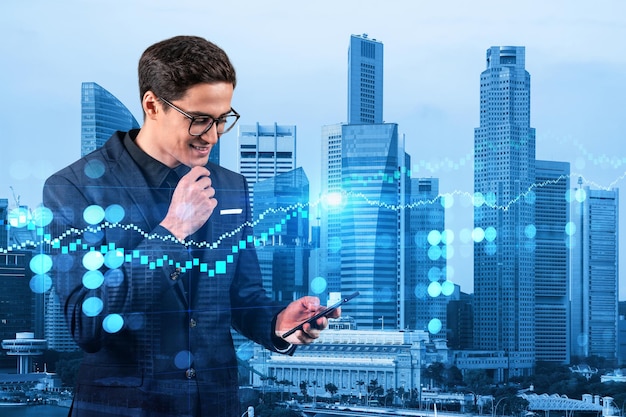 Handsome eastern trader checking quotes to forecast the capital market behavior Concept of trading strategy Forex chart Singapore Double exposure