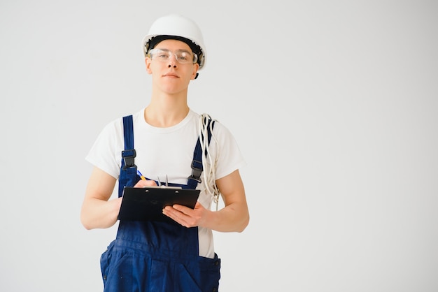 Handsome electrical engineer holding clipboard on white background