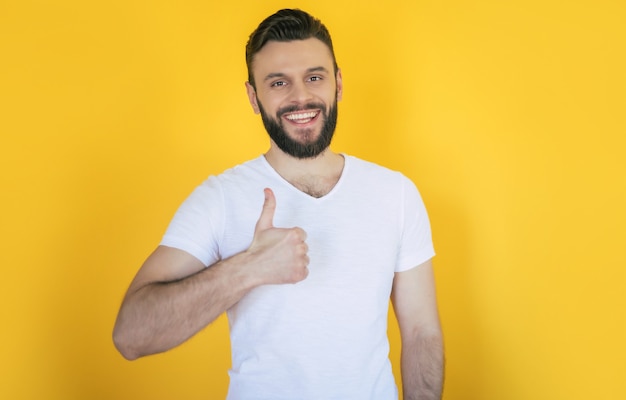 Handsome excited modern young bearded stylish man is posing with a wide toothy smile