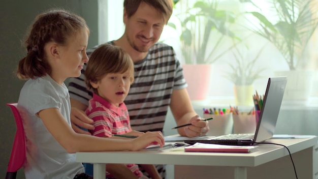 Handsome father helping his children with homework