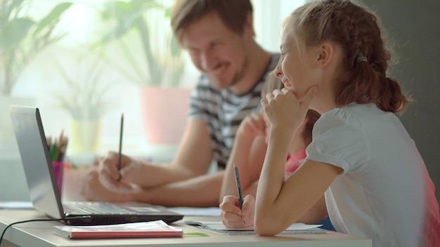 Handsome father helping his children with homework