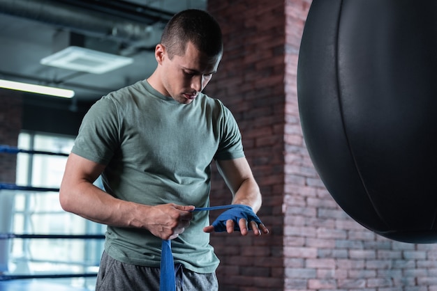 Handsome fighter. Young handsome promising fighter spending his day in gym before participating in competition