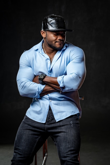 Handsome fit man wearing shirt Strong young man posing on black background