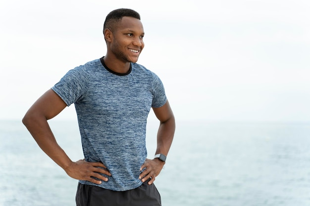 Handsome fitness multiracial man at the beach standing in relaxed pose