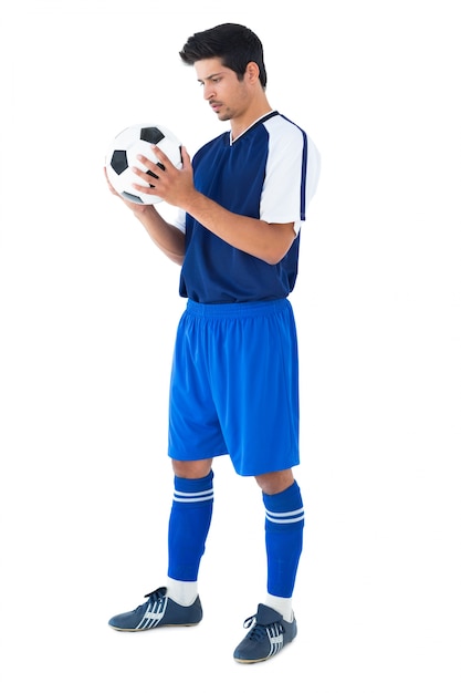 Handsome football player in blue holding the ball