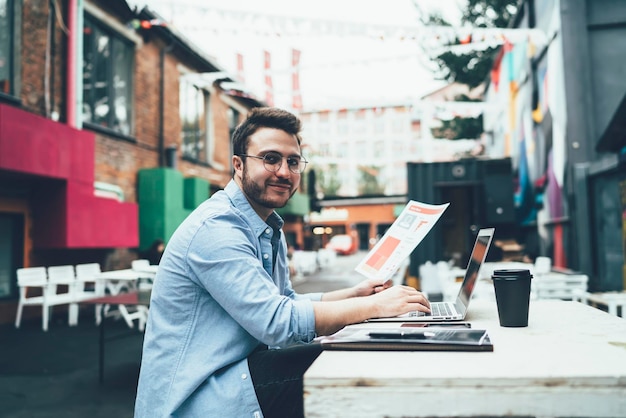 Photo handsome freelancer analyzing report in street