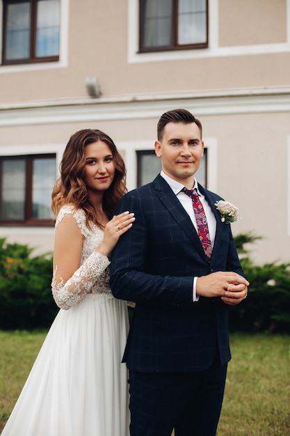 Handsome groom in black suit with beautiful bride in long white dress