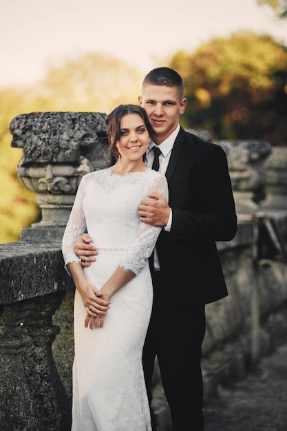 Handsome groom and his cute bride on the old balcony