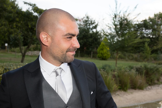 Handsome groom at wedding tuxedo smiling and waiting for bride.