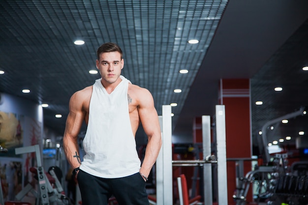 Handsome guy at fitness gym pose to camera