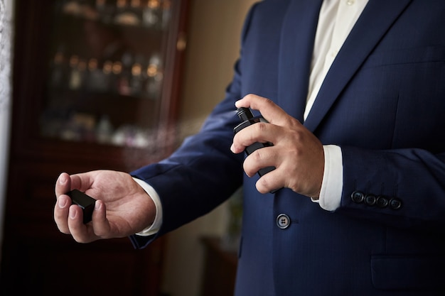 Handsome guy is choosing perfume for his wedding day