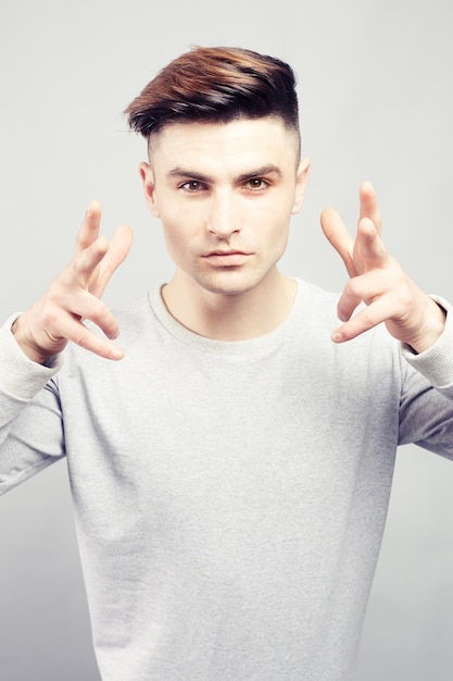 Handsome guy making an aggressive gesture with his fingers spread