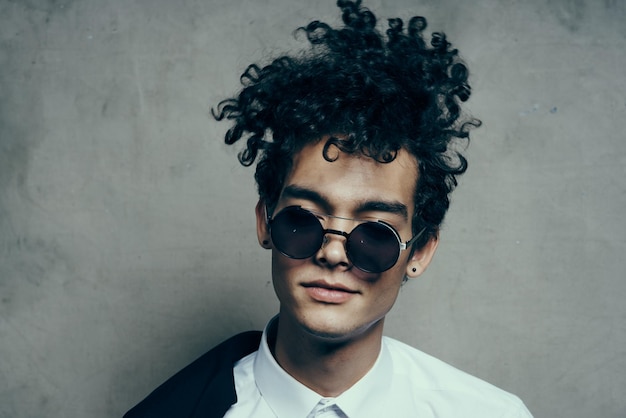 Handsome guy model in shirt and glasses jacket on shoulder portrait closeup